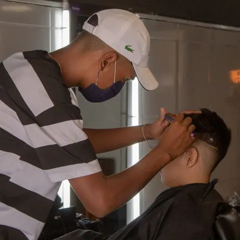 Barber trimming a client at the chair